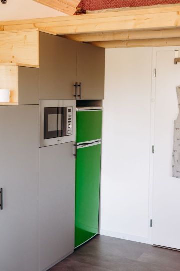 Pohled kuchyně na prostor naproti kuchyňské linky v tiny house, moderní a praktické řešení.